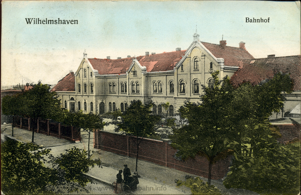 Die Straßenseite des Bahnhofs Wilhelmshaven um 1910. Noch ist der Vorplatz durch eine Mauer und Tore zur Straße hin abgeschlossen.