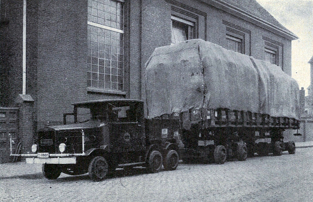Hochbeladener Rungenwagen auf einem Straßenfahrzeug vor dem Werk der Firma Kaiser